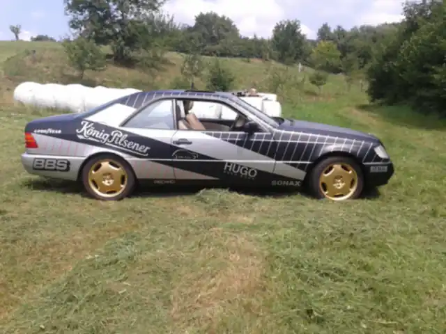 Mercedes S 500 Coupe mit Designfolierung in Schwarz-Weiß und Sponsorenlogos auf einer Wiese