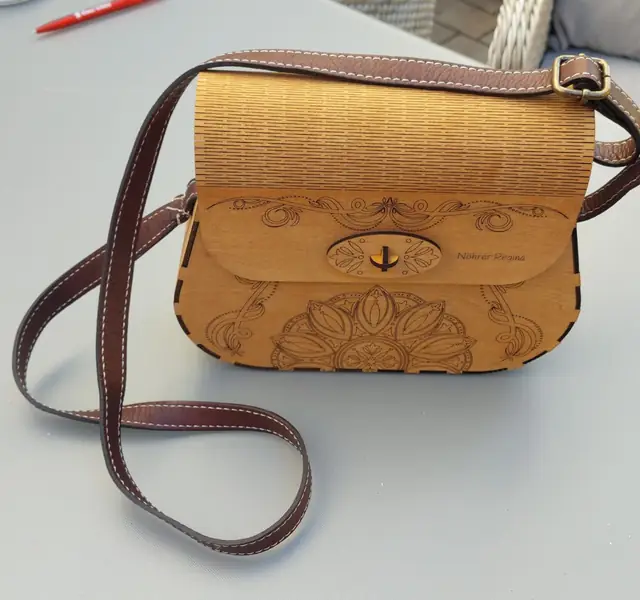 Handtasche aus gelasertem Holz mit Ornamenten und braunem Lederriemen