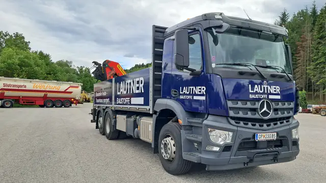 Mercedes-Kran-LKW in Blau mit Firmenbeschriftung, Frontansicht
