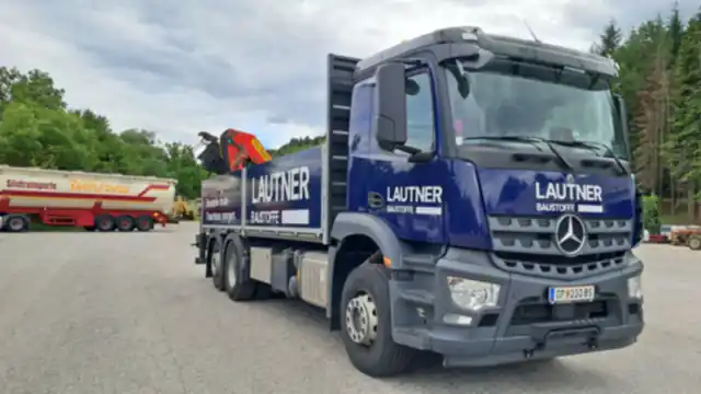Mercedes-Kran-LKW in Blau mit Firmenbeschriftung, Frontansicht