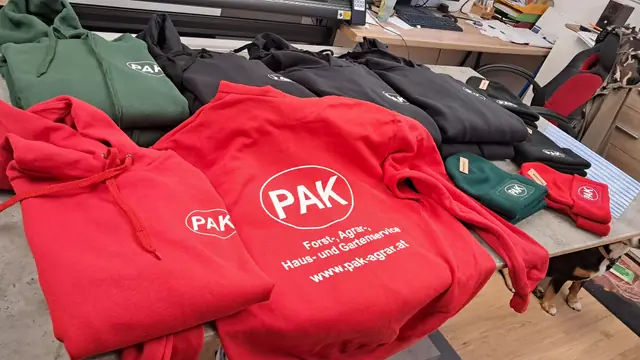 Rote und grüne Pullover mit aufgedrucktem Firmenlogo