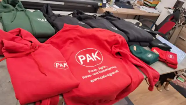 Rote und grüne Pullover mit aufgedrucktem Firmenlogo