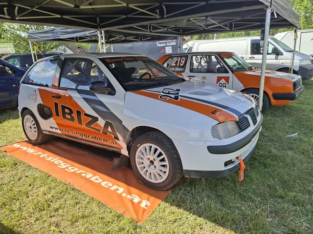 Weißer Seat mit orangefarbener Sponsorenbeklebung im Fahrerlager