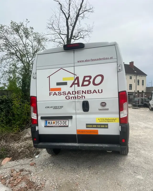 Weißer Kastenwagen mit Heckbeschriftung für einen Fassadenbau-Betrieb