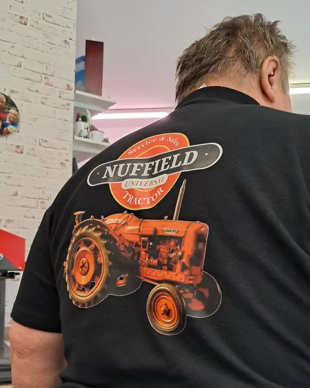 Schwarzes T-Shirt mit orangem Traktor-Motiv im Rückendruck