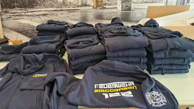 Bedruckte dunkelblaue Pullover einer Vereinsausstattung, fertig zum Ausliefern