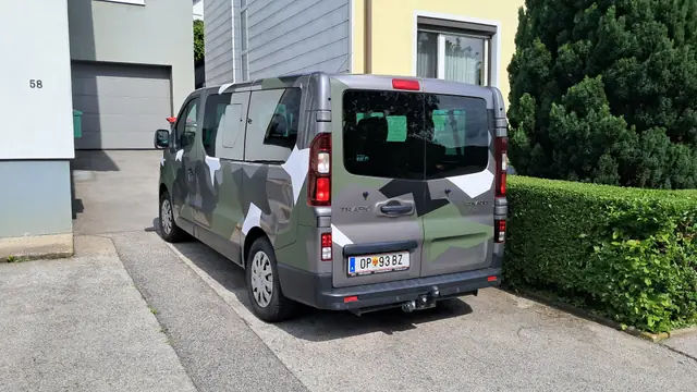 Heckansicht eines Transporters mit Camouflage-Vollfolierung vor der Werkstatt in Oberpetersdorf