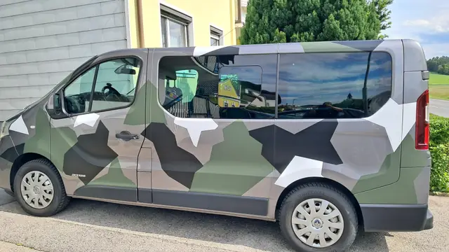 Transporter mit Vollfolierung im Camouflage-Design in Grün, Grau und Schwarz